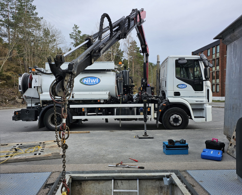 Niwi-tekniker utfører service og kontroll av sikkerhetsmekanismen på en bunntømt renovasjonscontainer.